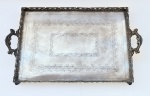 Grande tabuleiro em metal espessurado à prata com galeria vazada, alças laterais, fundo lavrado com folhagens e elevada por quatro pés em formato de garra. Med 69 x 42 cm. 