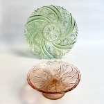 Prato para bolo em vidro antigo prensado na tonalidade verde e fruteira de pé alto na tonalidade rosa. Decoração floral com bordas recortadas. Med prato 28 cm de diâmetro, fruteira 20 x 8,5 cm. 