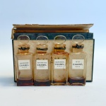 CHANEL - Quatro flacons em miniatura de renomadas fragrâncias: Gardênia, Cuir de Russie, N 5 e Bois de Iles. Estojo original com perdas. 6 cm os frascos.