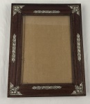 Antigo e elegante porta-retrato em madeira de lei,  apresentando entalhes texturizados e  apliques em prata com motivos florais e de rocalhas em relevo.  Dec. 1930 a 1950. Medindo: 38 x 47 cm moldura, 25 x 35 cm foto.