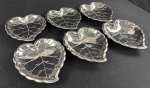 Seis travessas em inox. 'MERIDIONAL', em forma de folhas. Medidas: 26 x 22 x 3,5cm.