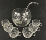 Conjunto para ponche em cristal translúcido, com rica lapidação geométrica e motivos de folhagens, composto por 8 peças: poncheira, concha e 6 xícaras com alças. Apresenta bicados e falta da tampa. Medidas: poncheira: 16 x 17 cm; concha: 30 cm de comprimento.