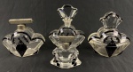 Conjunto para toilette em cristal translúcido facetado, com detalhes em esmalte negro e decoração de figuras femininas e motivos florais no estilo Art Déco, composto por 4 peças: 3 perfumeiros e caixa para pó de arroz. caixa Apresenta lascados. Medida da caixa: 10,5 x 10 x 5,5 cm.