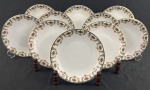 REAL. Dez pratos para sobremesa em porcelana esmaltada, com rica decoração policroma de motivos florais e arabescos nas bordas, realçada por filetes em ouro. Manufatura no verso. Medidas: 19 cm.