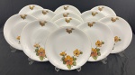 RENNER, modelo Madailon, Porto Alegre. Conjunto de 12 pratos rasos em porcelana branca esmaltada, decorados com arranjos florais policromados em tons alaranjados, rosados e verdes, realçados por delicado filete dourado na borda. Manufatura no verso. Medidas: 25 cm de diâmetro.
