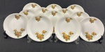 RENNER, modelo Madailon, Porto Alegre. Conjunto de 12 pratos para sobremesa em porcelana branca esmaltada, decorados com arranjos florais policromados em tons alaranjados, rosados e verdes, realçados por delicado filete dourado na borda. Manufatura no verso. Medidas: 17,5 cm de diâmetro.