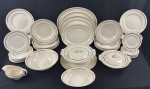 JOHNSON BROS, ENGLAND, modelo Old English. Serviço de jantar em faiança inglesa, com bordas molduradas em relevo e filetes dourados, composto por 61 peças: 23 pratos rasos, 12 pratos fundos, 1 prato para bolo, 8 pratos para sobrmesa, 9 pratos para pão, terrina, sopeira sem tampa, 2 saladeiras, molheira e 3 travessas. Medidas: pratos rasos: 25 cm; fundos: 3,5 x 25 cm; prato para bolo: 31 cm; sobremesa: 20 cm; pão: 16 cm; terrina: 12,5 x 26 x 23 cm; sopeira: 9 x 29 x 26 cm; saladeiras: 8 x 25,5 cm e 6 x 24 x 18 cm; molheira: 10 x 20 x 10,5 cm; travessas: de 30,5 x 24 cm a 40 x 31 cm. Apresenta sinais de uso e desgaste; 5 pratos rasos, 1 fundo, 3 de sobremesa e 7 para pão com bicados; sopeira com discreto bicado; uma saladeira com fio de cabelo e bicado.