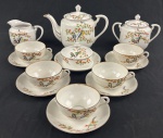 NagoyA,Japão. Conjunto de chá em porcelana fina japonesa, composto por 1 bule, 1 leiteira, 1 açucareiro, 1 manteigueira e 5 xícaras de chá com seus respectivos pires, decoração vegetalista com pássaros policromados, alguns desgastes no filete dourado das bordas e pequenas esbeiçadelas. 9 peças. Manufatura no verso. Medindo: 16 x 22 cm,8,5 x 12 cm,13 x 16 x 11 cm e 9 x 14 cm. 1 xicara com bicado.