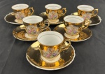 Conjunto de 6 xícaras de café de coleção com respectivos pires, em porcelana esmaltada e ricamente dourada, decorada com reservas policromadas representando cenas galantes ao gosto romântico, contornadas por arabescos brancos. Acondicionado em estojo original. Desgastes na douração