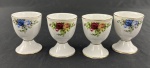 Donton Manor, Italy Design. Conjunto de 4 porta-ovos em porcelana fina italiana, no estilo Royal Albert, 2 ornamentadas com buquês de rosas vermelhas e amarelas, 2 com buquês de rosas em degradê de azul cobalto e lavanda, com folhagens em tons de verde-oliva. Medindo: 6,5 x 5 cm