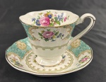Donton Manor, Italy Design. Xícara para chá de coleção com respectivo pires, em porcelana branca esmaltada, com rica decoração policromada de buquês florais, reservas em tom verde-turquesa e arabescos dourados. Bordas recortadas e filetadas a ouro. Manufatura no verso.