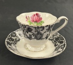 Donton Manor, Italy Design. Xícara para chá em porcelana italiana, ESTILO Royal Albert, padrão "Señorita" (Black Lace), modelo Montrose, exterior da xícara e a aba do pires são ornamentados com uma estampa que imita uma renda de bilro negra, interior apresenta uma rosa-pink, filetes e guarnições em ouro. Manufatura no verso.