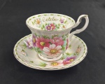 ROYAL ALBERT, BONE CHINA, Inglaterra, série Flower of the Month, modelo Cosmos, 1970. Xícara para, chá de coleção com respectivo pires, em porcelana inglesa, ricamente decorada com flores cosmos policromadas, alusivas ao mês de outubro, bordas recortadas e filetes dourados. Manufatura no verso.