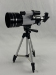 Telescópio astronômico e terrestre refrator, modelo F30070M, com estrutura metálica, abertura de 70 mm e distância focal de 300 mm. Acompanha tripé regulável, bolsa para transporte, oculares, visor diagonal, suporte para celular, acessórios diversos, manuais de instruções e caixa original. Funcionando.