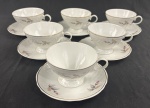 SCHMIDT, Santa Catarina. Seis xícaras de chá com seus pires em porcelana branca esmaltada, com decoração floral policromada, detalhes moldados em relevo e filetes prateados. Manufatura no verso.