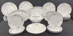 SCHMIDT. Serviço de jantar em porcelana branca esmaltada, com delicada decoração floral policromada, relevos moldados e filetes prateados, composto por 37 peças: 12 pratos rasos, 12 pratos fundos, 8 pratos de sobremesa, 3 travessas ovais, saladeira e sopeira com tampa. Manufatura no verso. Medidas: pratos rasos: 25,5 cm; fundos: 4 x 23 cm; sobremesa: 19 cm; travessas: de 28 x 18 cm a 36 x 22 cm; saladeira: 6,5 x 24 cm; sopeira: 25 x 30 x 22 cm. Três pratos rasos apresentam lascas e bicados; 1 prato fundo e a saladeira apresentam bicados.