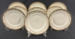 IVORY CHINA BY PORCELANA SCHMIDT BRASIL, Roberto Simões. Conjunto de 9 pratos para sobremesa em porcelana marfim esmaltada, com faixa decorativa policromada de motivos florais e arabescos, emoldurada por largas bordas douradas. Manufatura e assinatura identificadas no verso. Medindo: 19 cm.
