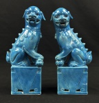 Par de Cães de Fó de cerâmica azul vitrificada.  Cão de Fó (ou Foo Dog/Fu Dog) é um símbolo asiático milenar de proteção, força e prosperidade, representando leões guardiões na cultura chinesa 26 x 12 x 7 cm. 1 cão com ausência da língua e 1 com perda na policromia.