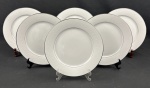 NORITAKE, Japão. Seis pratos rasos em porcelana japonesa modelo Buckinham, na cor branca com elegantes frisos prateados e desenhos florais leitosos. Medindo: 27 cm.