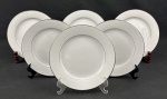NORITAKE, Japão. Seis pratos para sobremesa em porcelana japonesa modelo Buckinham, na cor branca com elegantes frisos prateados e desenhos florais leitosos. Medindo: 21 cm.