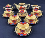 Aparelho de Chá, manufatura Ditmar Urbach A.G. (Teplitz-Turn, antiga Checoslováquia), década de 1920 / 1930 (período Art Deco), em faiança esmaltada com rica decoração floral policromada sobre fundo amarelo, base timbrada com a marca do fabricante e identificação do modelo "DORA". Composto: 1 bule para chá, falta a tampa(13 x 25 cm), 1 açucareiro (11 x 18 cm), 1 Cremeira (8 x 14 cm), 1 Manteigueira (7 x 17 cm) e  5 Xícaras de chá com pires (2 xícaras e 2  pires com bicados/defeitos).