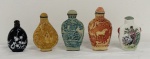Conjunto de cinco pequenos frascos de rapé chineses (snuff bottles), em materiais e formatos variados, com tampas, decorados em relevo e pintura policromada, apresentando figuras orientais, paisagens, animais e motivos florais. Alturas: 6 cm a 8 cm.