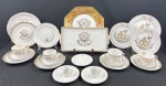 Conjunto comemorativo de Bodas de Ouro em porcelana, composto por xícaras de chá e de café com respectivos pires, pratos de diferentes formatos e travessa retangular. Decoração alusiva aos 50 anos de casamento, com alianças, pombas, arabescos, monogramas e frisos dourados. Medidas das principais peças: 4 x 30 cm; 20 cm, 19 cm, 25 cm e 19 cm de diâmetro; travessa 34 x 18 cm. Apresenta leves desgastes no dourado.