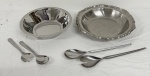 TRAMONTINA, linha Primavera. Conjunto para servir salada em aço inoxidável, composto por duas saladeiras e quatro talheres de serviço. Uma saladeira apresenta borda gravada com motivos estilizados e acompanha embalagem original e par de talheres; a outra possui borda recortada e lavrada, acompanhada de dois talheres. Total: 6 peças.