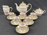REAL BRANCO GUANABARA, BRASIL. Serviço para café em porcelana, composto por bule, açucareiro com tampa, leiteira e seis xícaras de café com respectivos pires. Decoração floral em policromia, com faixas ornamentais, reservas iridescentes e profuso acabamento dourado. Manufatura no verso.  Medidas: bule 20 x 19 cm; açucareiro 11 x 12 cm; leiteira 10 x 15 cm. Uma xícara apresenta bicado.