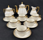 LIMOGES P.L., FRANÇA. Serviço para chá em porcelana branca, em estilo Art Déco, composto por bule, açucareiro com tampa, leiteira e seis xícaras com respectivos pires. Peças de corpos facetados, com alças geométricas e decoração em frisos dourados. Total: 15 peças. Marca do fabricante na base. Medidas, respectivamente: 20 x 19 cm; 11 x 12 cm; 16 x 15 cm.