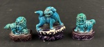 Conjunto de três pequenas esculturas orientais emesmaltada, representando cães de Fô sobre bases ornamentadas, em tons de azul-turquesa e púrpura. Medidas: maior 8 x 7 cm; menores 6 x 5 cm cada. A peça maior apresenta desgaste no esmalte.
