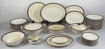 ALFRED MEAKIN. Aparelho de jantar com 60 peças em faiança Inglesa, esmaltagem bege com faixa vinho decorada a ouro. Composto de: Sopeira, terrina, molheira, saladeira, 5 travessas ovais rasas, 2 travessas ovais fundas, 1 travessa redonda, 24 pratos rasos (7 com amarelados), 12 pratos fundos e 12 pratos de sobremesa (3 com amarelados). 3 travessas fundas com amarelado, 1 travessa funda, 1 prato de sobremesa e um prato raso com lascado na borda. 1 prato raso com fio de cabelo e um prato de sobremesa com fio de cabelo). Medindo:   22 cm, 4 x 22,5 cm, 17 cm, 12 x 29 x 26 cm, 31 cm, 11 x 25 x 22 cm, 9 x 24 cm, 8 x 20 cm, 7 x 18 cm, 7 x 16 x 11 cm, travessas ( 14 x 20 cm à 37 x 30 cm).