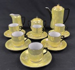 Serviço para café em porcelana, em estilo Art Déco, composto por bule, açucareiro com tampa, leiteira e seis xícaras de café com respectivos pires. Decoração em esmalte nacarado amarelo, com alças, bico, puxadores e filetes em preto. Sem marca aparente. O bule apresenta lascado na borda, junto à tampa, e o conjunto possui leves desgastes no esmalte.