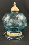 Antigo lustre pendente com globo em vidro azul lapidado com motivos geométricos e estrelados, guarnições em metal pintado, corrente e canopla. Apresenta bicado no vidro, marcas do tempo e desgastes na pintura metálica. Medidas: 32 x 25 cm.