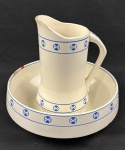 Antigo conjunto em faiança europeia, composto por bacia e jarro, com decoração geométrica em azul aplicada por estêncil. Apresenta marca de registro Geschützt e inscrições na base. Medidas: bacia 10 x 30 cm; jarro 18 x 25 x 15 cm. A bacia apresenta bicado na borda.