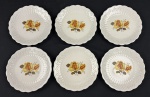 Seis pratos para sobremesa em porcelana branca, esmaltado com rosas ao centro, detalhes em relevo e bordas onduladas. Medindo: 18 cm.