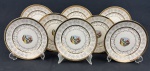 Oito pratos para sobremesa em faiança, decorados cenas campestres e figuras em trajes de época ao centro, cercadas por delicada decoração floral e rica douração, marcado no verso. Medindo: 17,5 cm. Um com bicado.