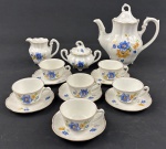Conjunto para café em porcelana polonesa, na cor branca com decoração floral em azul e amarelo, folhas verdes e delicados filetes dourados nas bordas. Sendo bule, leiteira, açucareiro e seis xicaras para café com pires. Medindo: 18 x 20 cm, 8,5 x 10 cm, 8,5 x 12 cm. Uma xicara com bicado seguido de fio.