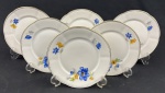 Seis pratos para sobremesa em porcelana polonesa, na cor branca com decoração floral em azul e amarelo, folhas verdes e delicados filetes dourados nas bordas. Medindo: 17 cm.