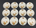RENNER, modelo Madailon, Porto Alegre. Conjunto de 12 pratos para pão em porcelana branca esmaltada, decorados com arranjos florais policromados em tons alaranjados, rosados e verdes, realçados por delicado filete dourado na borda. Manufatura no verso. Medidas: 14 cm de diâmetro.