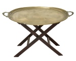 Tabuleiro oval com alças em metal dourado, estilo "Inglês",  Estrutura articulada em madeira escurecida em formato de "X". (Pequeno trecho da borda necessitando de reparo).Bandeja.     82 x 57 cm Base;  46 x 36 x 47 cm  ( aberto )