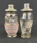 Par de coqueteleiras vintage em vidro, ambas com tampas metálicas originais, apresentando diferentes padrões decorativos característicos de peças antigas de bar e cristaleira. Medindo: 22 e 23 cm.