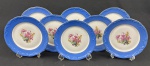 Schmidt. Oito pratos para sobremesa em porcelana nacional, esmaltado e policromado, decoração em relevo, borda azul e medalhão central de flores. Manufatura no verso. Medindo: 18 cm.
