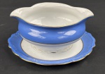 Schmidt. Molheira em porcelana nacional, esmaltado e policromado, decoração em relevo, borda azul e medalhão central de flores. Manufatura no verso. Medindo: 8 x 17 cm.