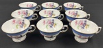 Schmidt. Nove xícaras de chá sem pires em porcelana nacional, esmaltado e policromado, decoração em relevo, borda azul e medalhão central de flores. Manufatura no verso. (2 com fio de cabelo).