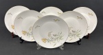 Rosenthal, Germany. Seis pratos rasos em porcelana alemã esmaltada na cor branca delicados ramos floridos e folhagens, finalizados por fino filetes em ouro. Manufatura no verso. Medindo: 25 cm.
