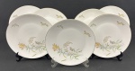 Rosenthal, Germany. Sete pratos rasos em porcelana alemã esmaltada na cor branca delicados ramos floridos e folhagens, finalizados por fino filetes em ouro. Manufatura no verso. Medindo: 25 cm.