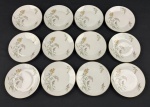Rosenthal, Germany. Doze pratos para pão em porcelana alemã esmaltada na cor branca delicados ramos floridos e folhagens, finalizados por fino filetes em ouro. Manufatura no verso. Medindo: 15 cm. Um com ínfimo bicado.
