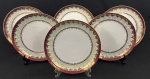 Schmidt. Seis pratos rasos em porcelana branca, com larga faixa furta-cor, borda em tom vinho e profusa ornamentação dourada. Manufatura no verso. Medidas: 25 cm de diâmetro.