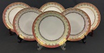 Schmidt. Seis pratos fundos em porcelana branca, com larga faixa furta-cor, borda em tom vinho e profusa ornamentação dourada. Manufatura no verso. Medidas: 3,5 x 22 cm de diâmetro.